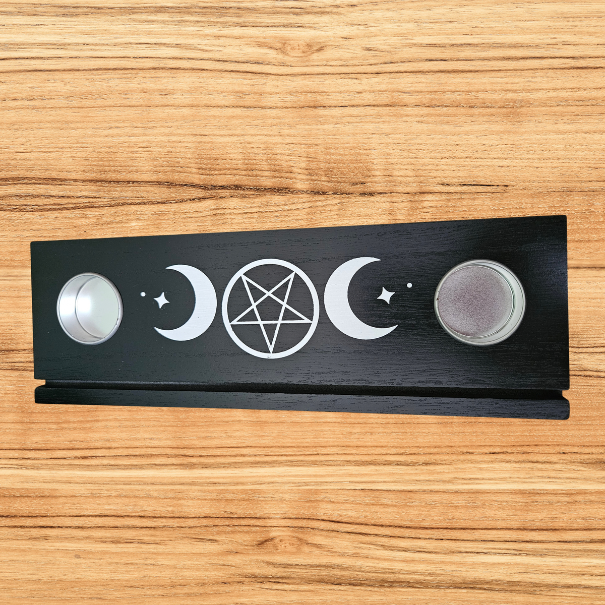 Black wooden Triple Moon tarot card holder with pentacle design, three tarot cards and two tealight holders.