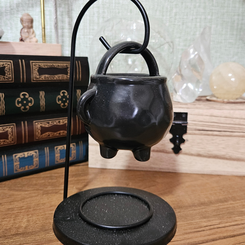 Black hanging cauldron wax melt and fragrance oil burner on a metal stand.
