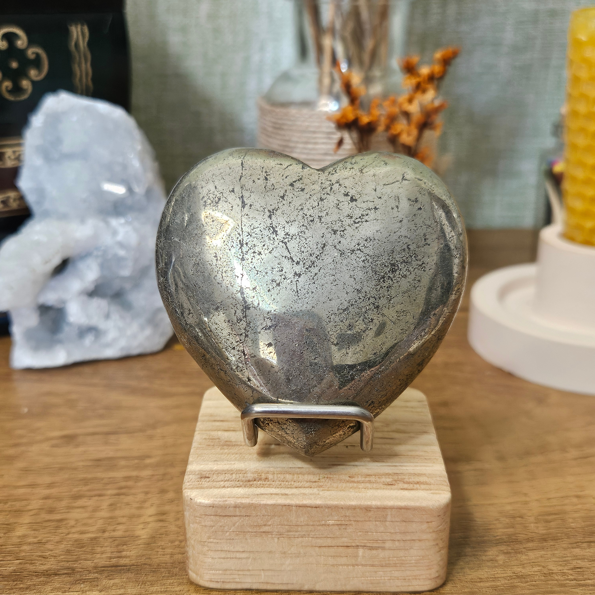 Close-up of a polished Pyrite heart showing its reflective metallic golden surface and natural mineral patterns.