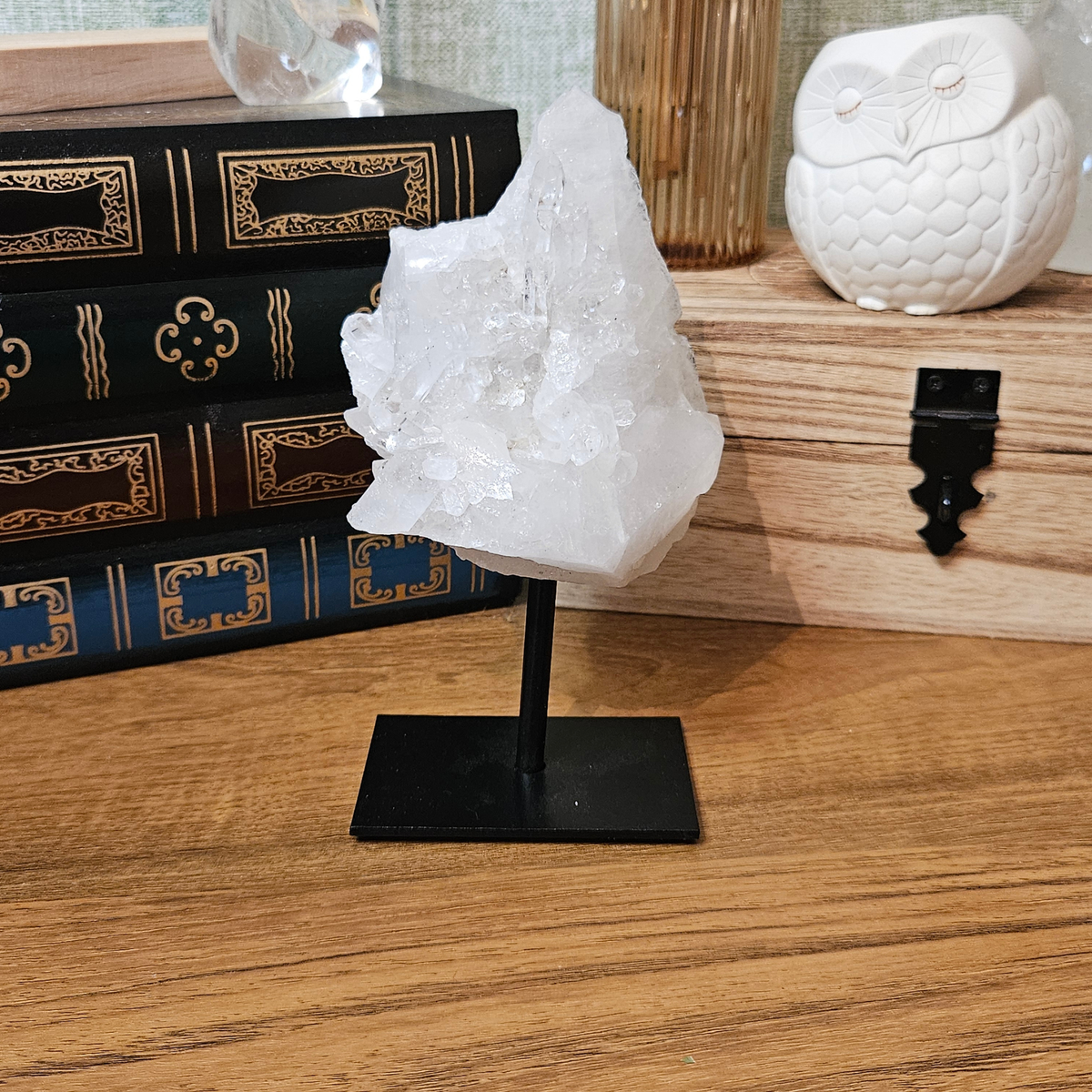 Brazilian clear quartz mineral specimen mounted on a black metal stand, approximately 85mm wide