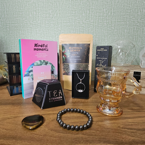 Protect Your Peace Corporate Survival Kit gift box with crystal jewellery, Tiger's Eye worry stone, aura spray, tea, smoky glass mug, Smoky Quartz tea infuser and affirmation cards.