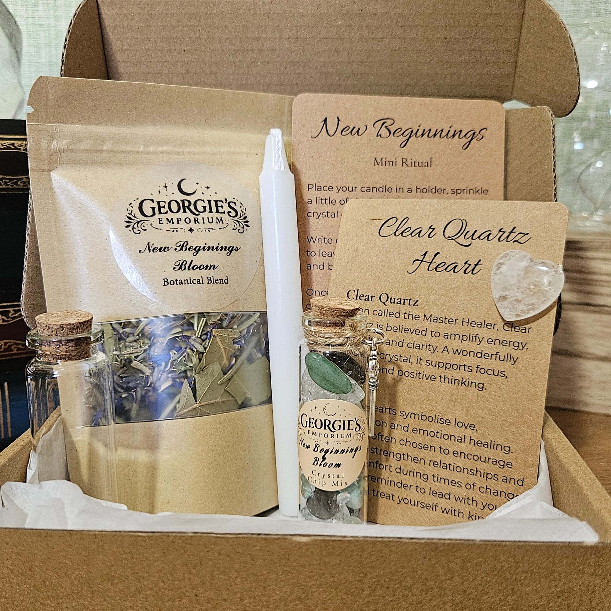 New Beginnings Bloom mini ritual box with clear quartz, crystal chips, botanical blend, candle, key charm and guided fresh start ritual.