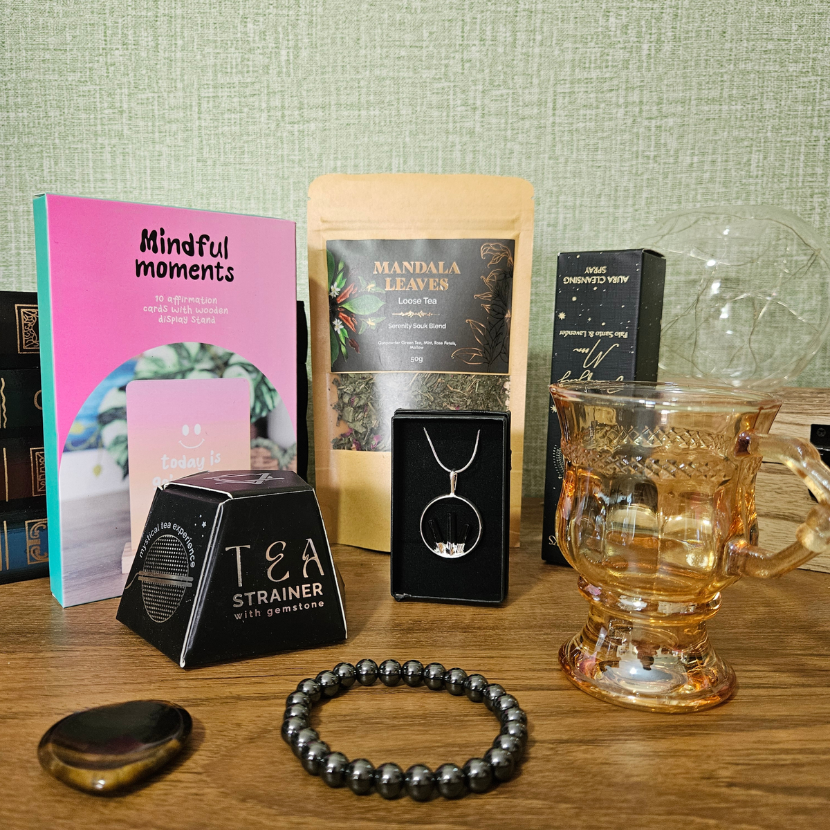 Protect Your Peace Corporate Survival Kit gift box with crystal jewellery, Tiger's Eye worry stone, aura spray, tea, smoky glass mug, Smoky Quartz tea infuser and affirmation cards.
