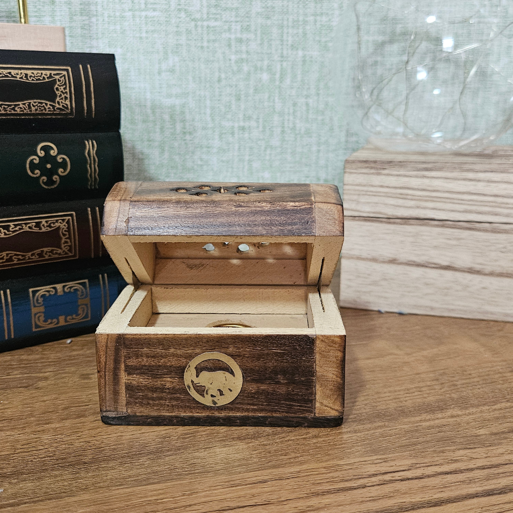 Open wooden treasure chest incense cone holder showing interior compartment for incense cone
