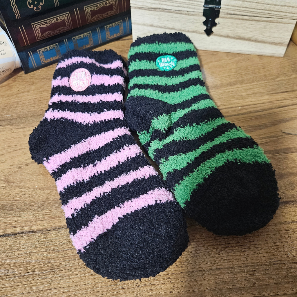 Boxed set of Good Witch pink and black and Bad Witch green and black fluffy striped socks.