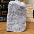 Close-up of natural amethyst quartz cluster showing purple crystal points and textured formations