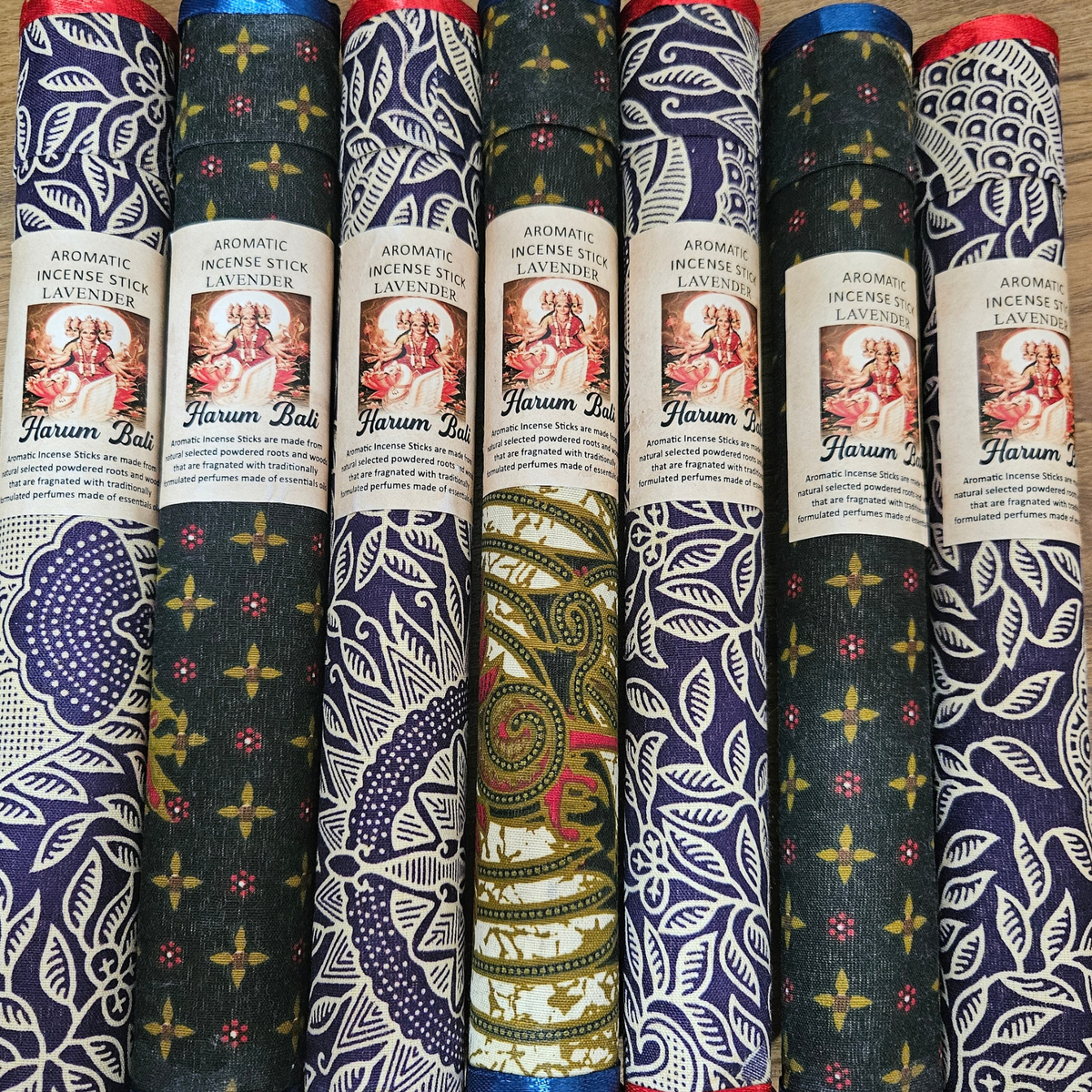 Lavender aromatic incense sticks in assorted decorative fabric-covered tubes.