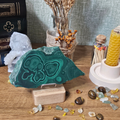 Natural 150g Malachite slice displayed on a wooden stand with distinctive dark and bright green banding.