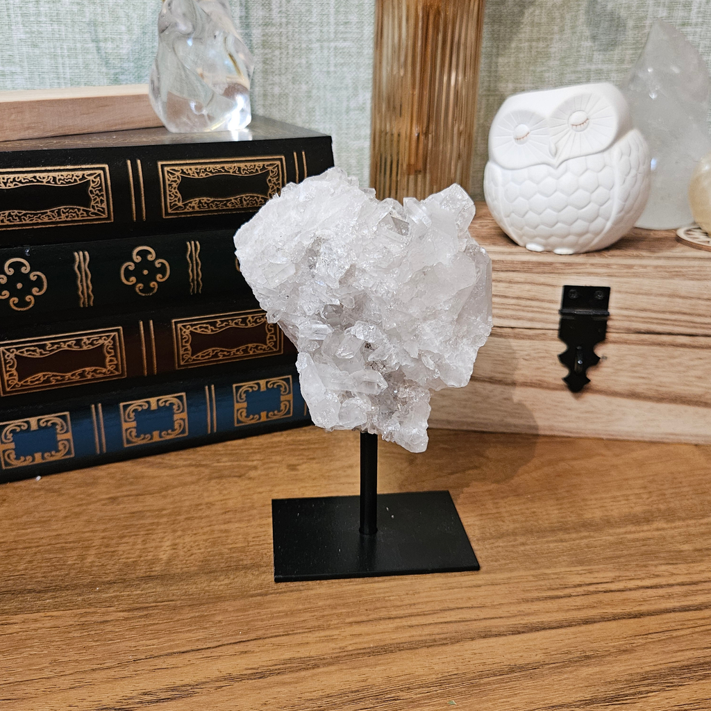Quartz druze crystal display on a metal base, showing the natural mineral formation and sparkling crystal surface