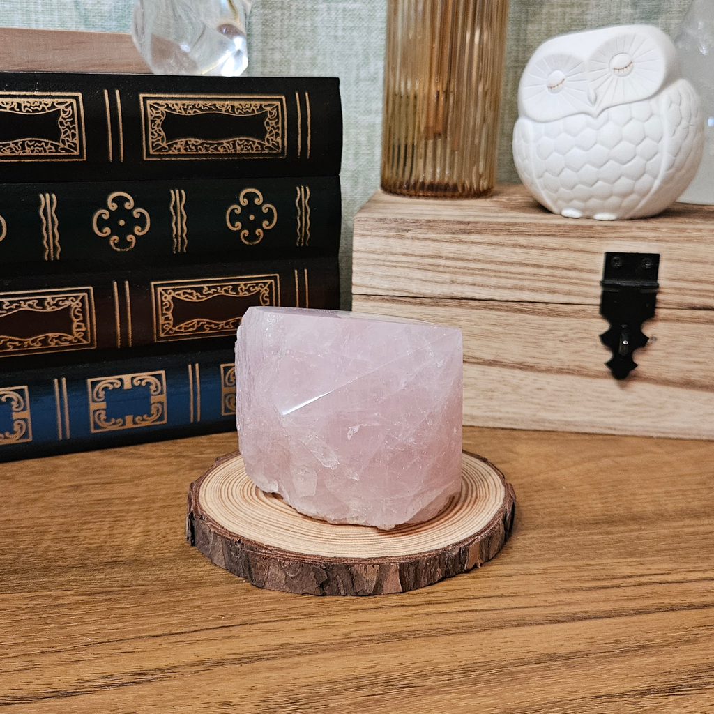 Natural rose quartz crystal from Madagascar showing smooth polished finish and contrasting unpolished base