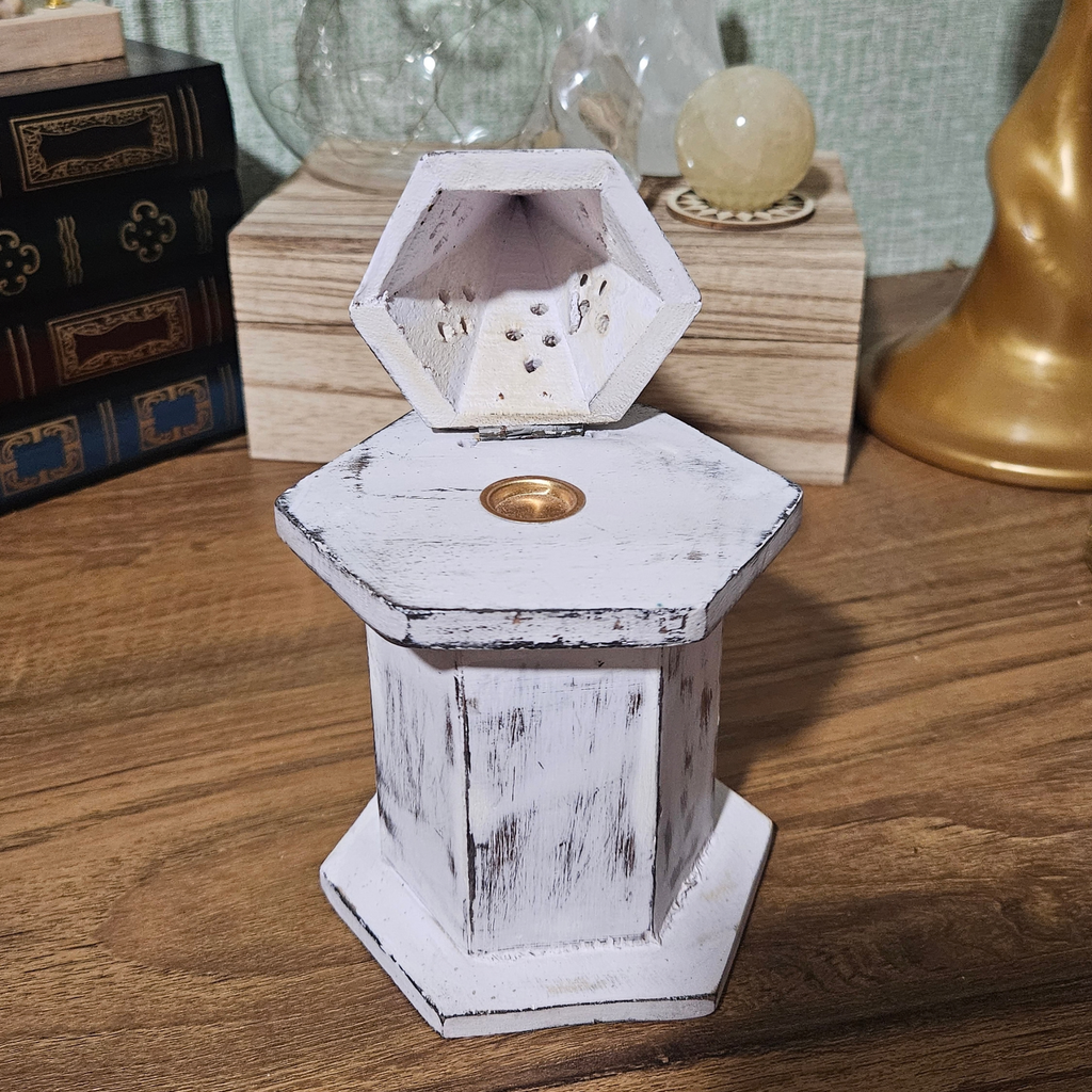 Distressed white wooden incense cone burner with hexagonal base, hinged pyramid lid and decorative smoke vents.