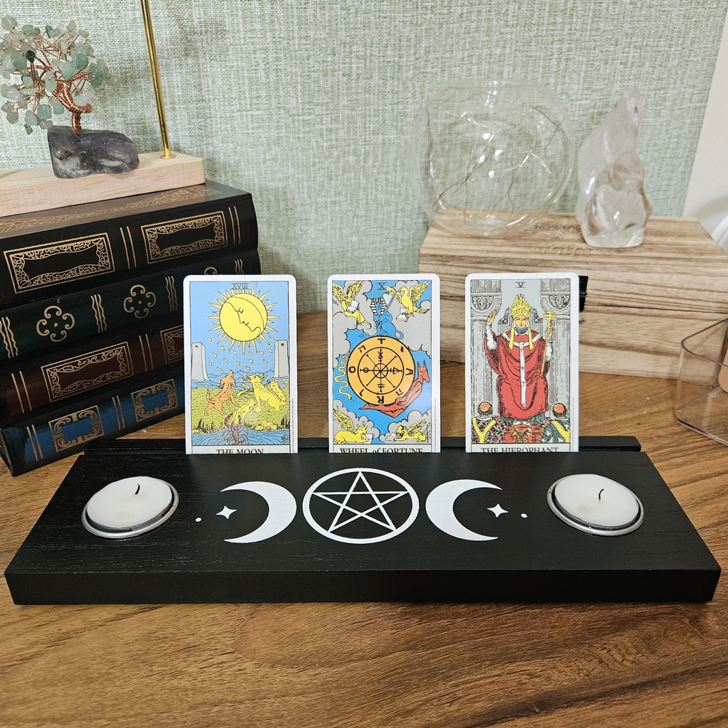 Black wooden Triple Moon tarot card holder with pentacle design, three tarot cards and two tealight holders.